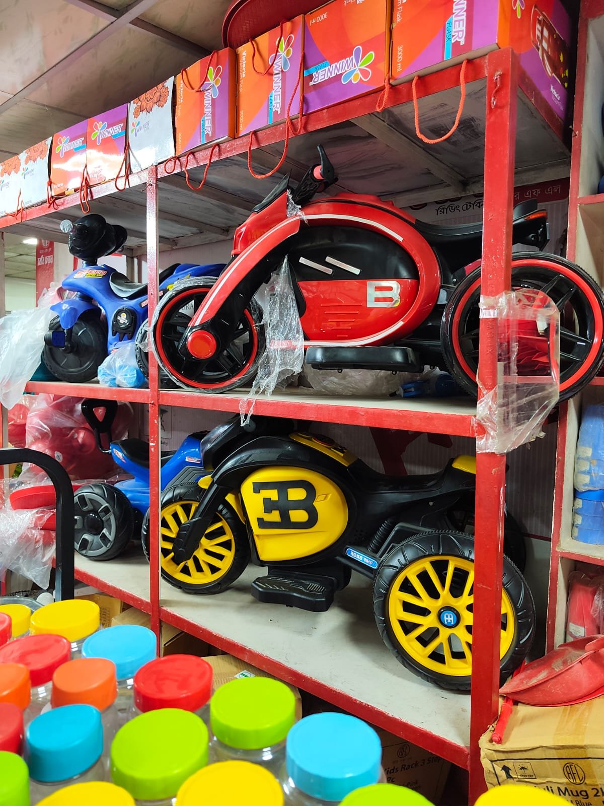 Red and yellow children's ride-on motorcycles on display