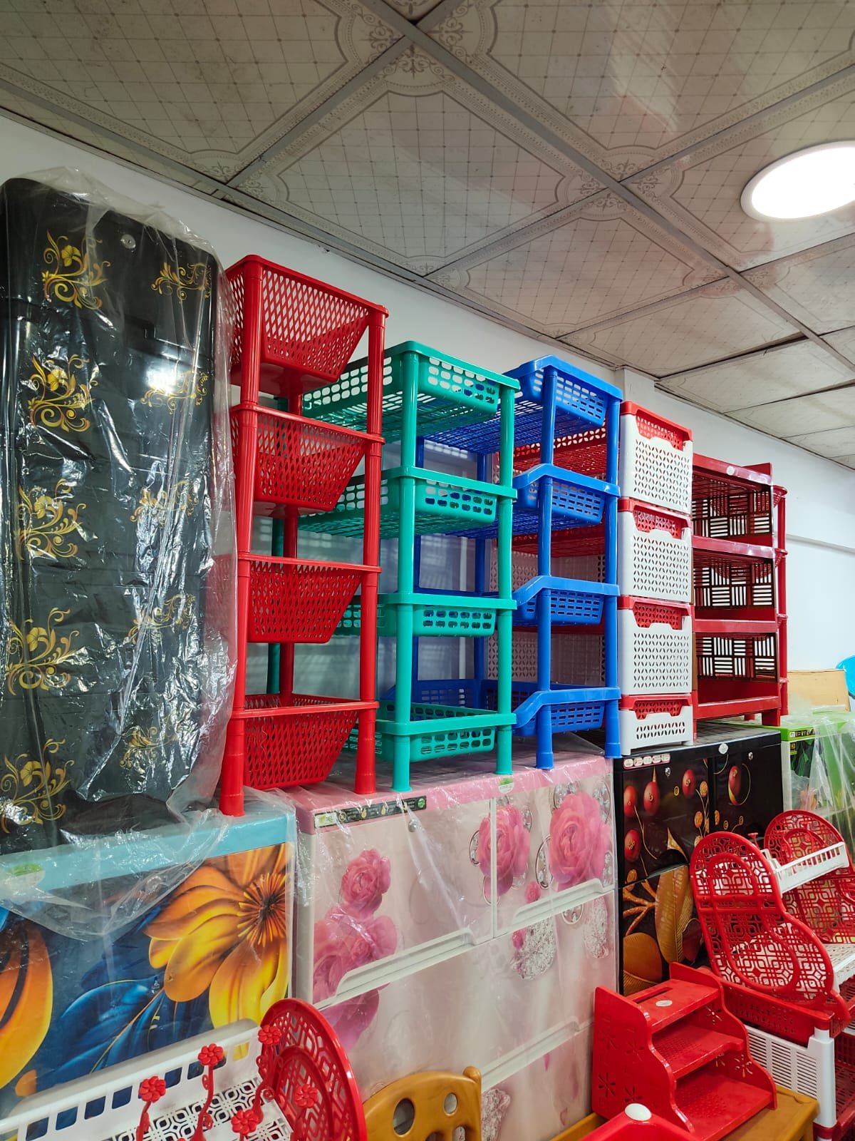 Red, green and blue storage racks above floral cabinets