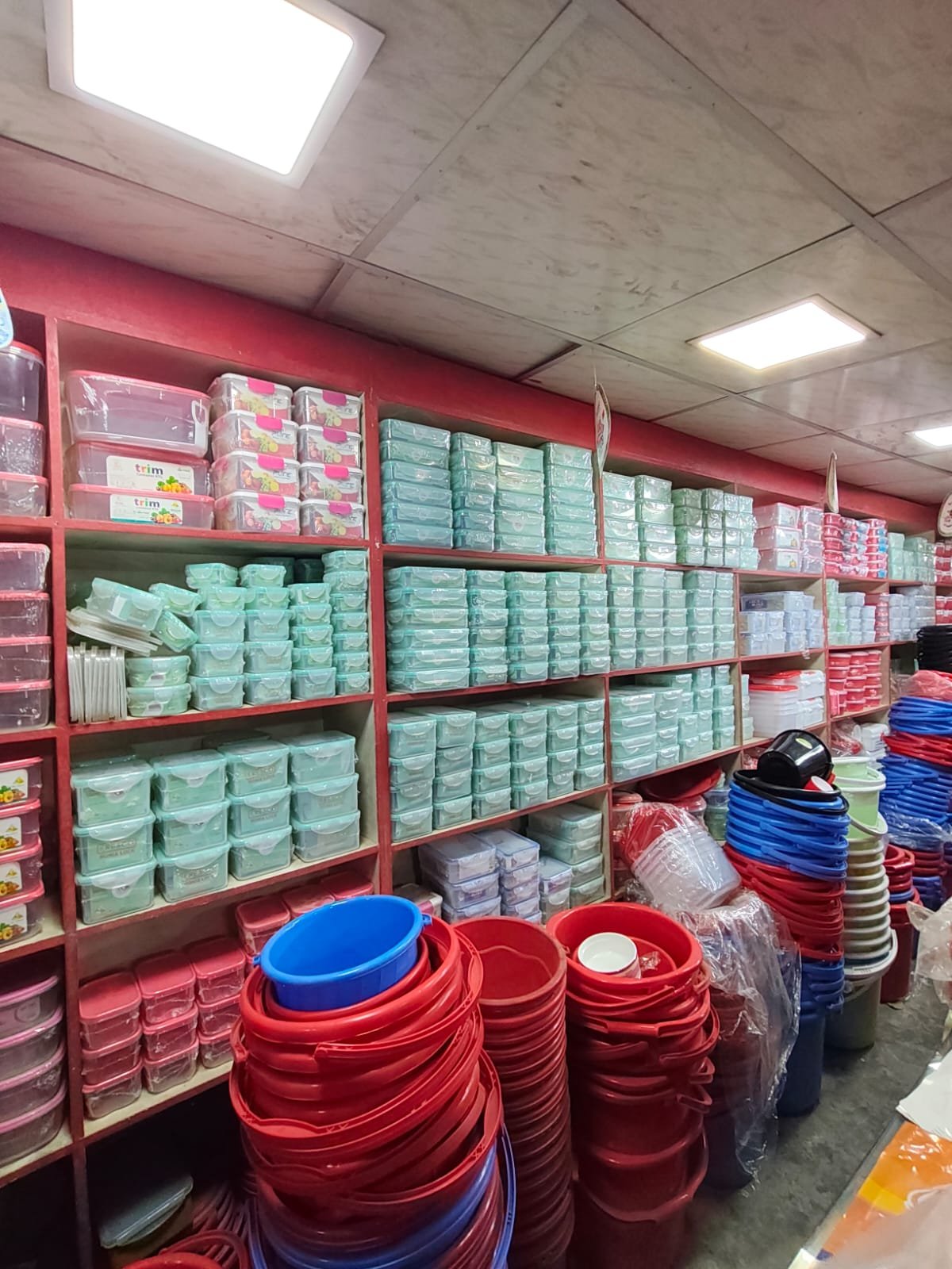 Shelves of food containers with buckets displayed below